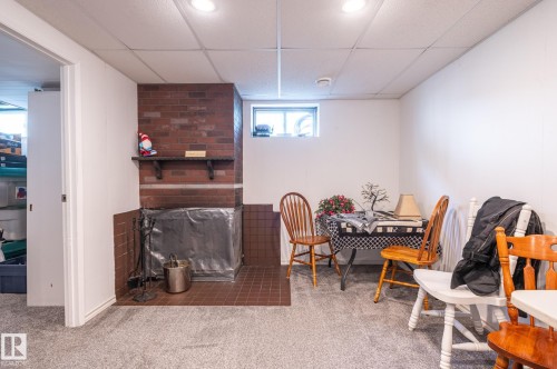 Brick fireplace with tiled hearth and mantel, recessed lighting, and a drop ceiling - 13816 62 Street, Edmonton, AB 