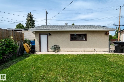 Detached rear garage with a stucco exterior, asphalt shingle roof, and a side access door - 13816 62 Street, Edmonton, AB 