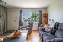 Living area featuring wood-finish flooring, a large window with exterior visibility - 13816 62 Street, Edmonton, AB 