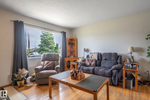 Bright living area featuring a large picture window, wood-finish flooring, a neutral wall color - 13816 62 Street, Edmonton, AB 