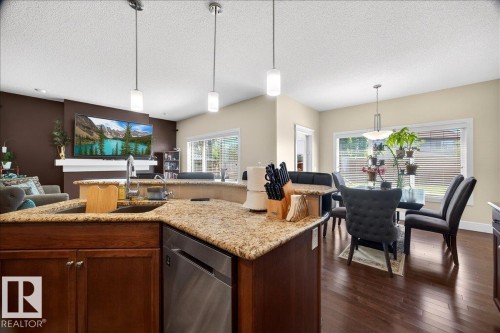 Kitchen island featuring a stainless steel sink, granite countertops, and pendant lighting - 1411 30 Avenue, Edmonton, AB 