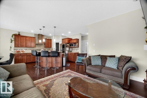 Kitchen featuring rich wood cabinetry, stainless steel appliances, a breakfast bar, and pendant lighting - 1411 30 Avenue, Edmonton, AB 