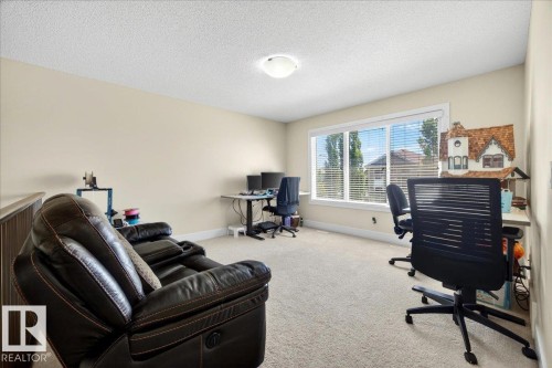 Spacious room featuring neutral paint, carpet flooring, a large window with white blinds, and a flush mount ceiling light - 1411 30 Avenue, Edmonton, AB 