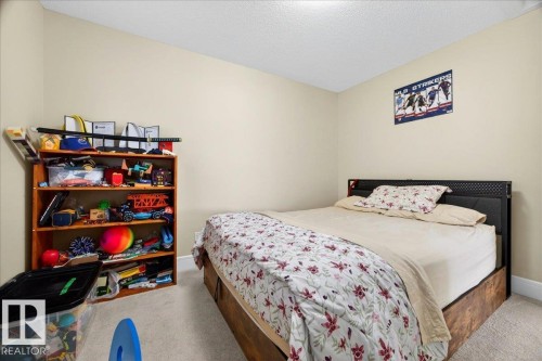 Bedroom featuring neutral wall paint, textured ceiling, and carpet flooring - 1411 30 Avenue, Edmonton, AB 