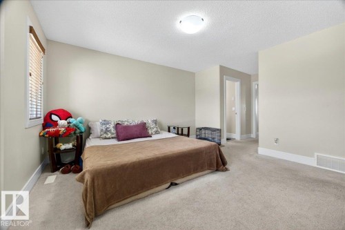 Spacious room featuring neutral wall tones, textured ceiling, and light-toned carpeting - 1411 30 Avenue, Edmonton, AB 