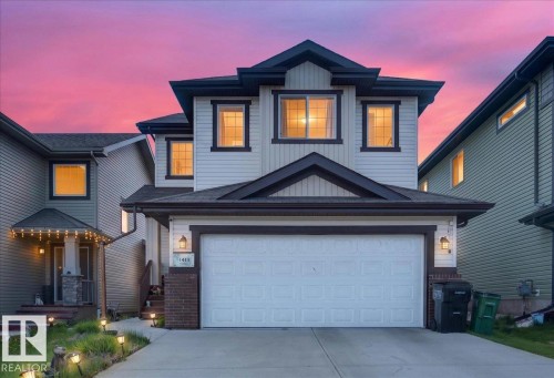 Two-story property featuring a double-wide concrete driveway and an attached two-car garage - 1411 30 Avenue, Edmonton, AB 