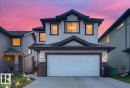 Two-story property featuring a double-wide concrete driveway and an attached two-car garage - 1411 30 Avenue, Edmonton, AB 