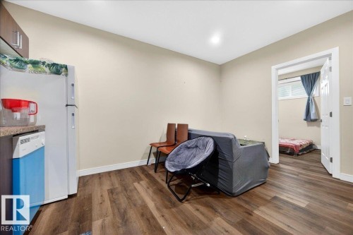 Open concept living space featuring wood-finish flooring, recessed lighting, and a neutral color palette - 1411 30 Avenue, Edmonton, AB 