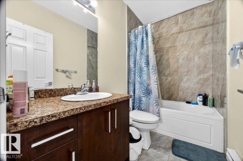 Bathroom vanity with a brown patterned countertop, under-mount sink, and dark wood-finish cabinetry - 1411 30 Avenue, Edmonton, AB 