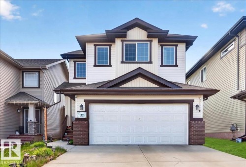 Two-story residence featuring white siding with dark trim accents and a prominent attached two-car garage - 1411 30 Avenue, Edmonton, AB 