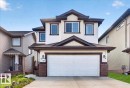 Two-story residence featuring white siding with dark trim accents and a prominent attached two-car garage - 1411 30 Avenue, Edmonton, AB 