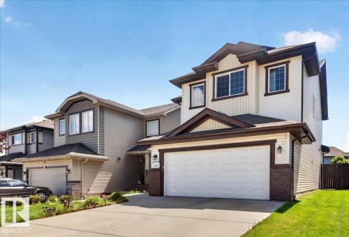 Contemporary multi-level residence featuring a two-car garage, mixed siding, and dark trim accents - 1411 30 Avenue, Edmonton, AB 