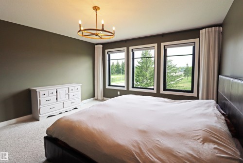 Expansive primary retreat with great views of the golf course. - 100 Graybriar Drive, Stony Plain, AB - Indoor Photo Showing Bedroom