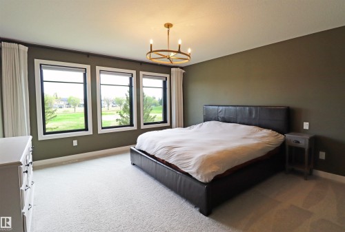 Expansive primary retreat with great views of the golf course. - 100 Graybriar Drive, Stony Plain, AB - Indoor Photo Showing Bedroom