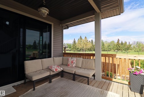 Covered deck with a wood railing and ample outdoor space with golf course view south AND east - 100 Graybriar Drive, Stony Plain, AB - Outdoor With Deck Patio Veranda With Exterior