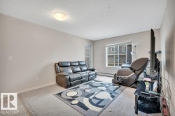 Bright living area featuring neutral wall tones, carpet flooring, a large window, and a flush mount ceiling light fixture - 