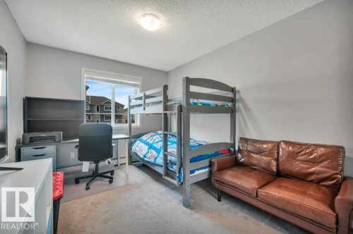 Bright room with neutral gray walls, a window offering exterior exposure, light-colored carpet flooring, and a flush-mount ceiling light fixture - 219 1820 Rutherford Road, Edmonton, AB 