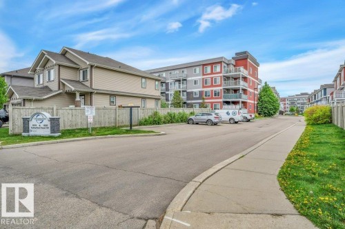 Two-story residential building with light-colored siding and brown trim - 219 1820 Rutherford Road, Edmonton, AB 