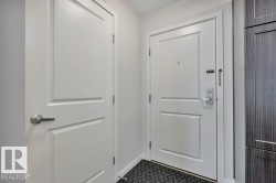Entryway featuring a panel door with brushed nickel hardware, a secure entry door with a deadbolt and chain lock, and dark wood-finish cabinetry - 