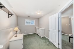 Room featuring neutral wall tones, green carpeting, and a white interior door - 