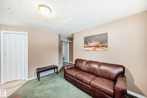 Interior room featuring a neutral wall color, green carpet, and a bi-fold door - 9813 152 Street, Edmonton, AB 