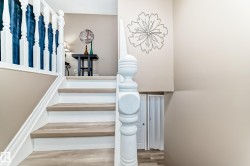 Staircase featuring wood-finish treads, white risers, and a white baluster railing - 
