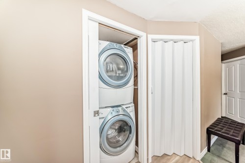Dedicated laundry alcove featuring a stacked washer and dryer unit - 9813 152 Street, Edmonton, AB 