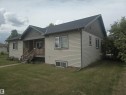Single-story residence featuring light-colored horizontal siding and a dark shingled roof - 4808 50 Avenue, Lamont, AB 