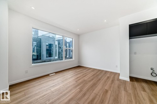 Spacious room featuring wood-finish flooring, recessed lighting, and a large multi-pane window - #66 5 Rondeau Dr, St. Albert, AB - Indoor Photo Showing Other Room