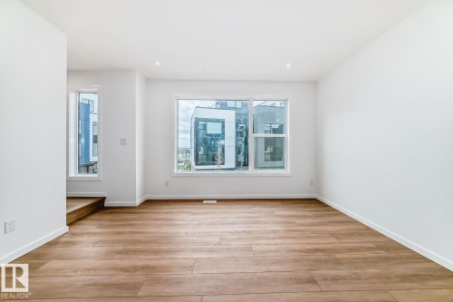 Bright interior space featuring wood-finish flooring, crisp white walls, and contemporary recessed lighting - #66 5 Rondeau Dr, St. Albert, AB - Indoor Photo Showing Other Room