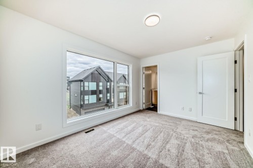 Spacious room with a large window, light-toned walls, and patterned carpeting - #66 5 Rondeau Dr, St. Albert, AB - Indoor Photo Showing Other Room