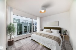 Expansive window with a contemporary urban backdrop, plush patterned carpeting, built-in ceiling light fixture, and floor-to-ceiling white window treatments - 