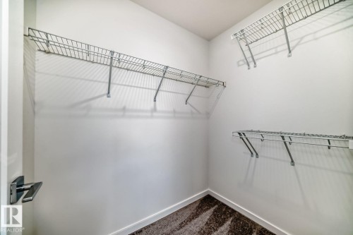 Walk-in closet featuring white walls, wire shelving, and patterned carpeting - #66 5 Rondeau Dr, St. Albert, AB - Indoor With Storage