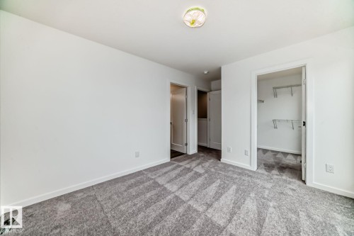 Room featuring grey patterned carpeting, white walls, white baseboards, and a flush mount ceiling light fixture - #66 5 Rondeau Dr, St. Albert, AB - Indoor Photo Showing Other Room