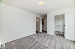 Room featuring grey patterned carpeting, white walls, white baseboards, and a flush mount ceiling light fixture - 