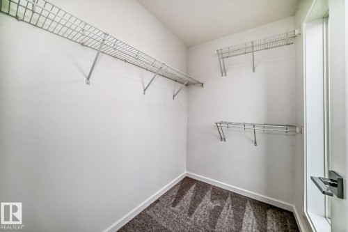 Spacious closet featuring white walls, wire shelving, and patterned carpeting - #66 5 Rondeau Dr, St. Albert, AB - Indoor With Storage