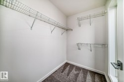 Spacious closet featuring white walls, wire shelving, and patterned carpeting - 