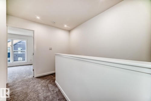 Loft area featuring a white half-wall railing, recessed ceiling lighting, and neutral wall paint - #66 5 Rondeau Dr, St. Albert, AB - Indoor Photo Showing Other Room