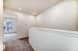 Loft area featuring a white half-wall railing, recessed ceiling lighting, and neutral wall paint - 