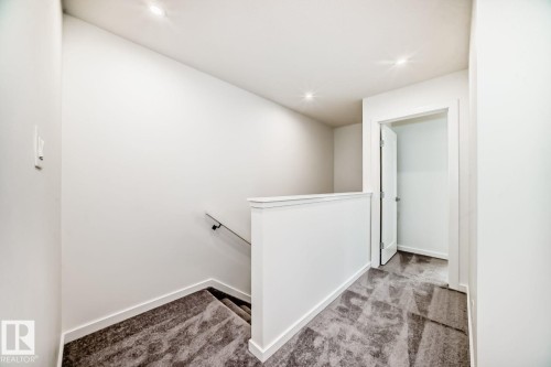 Open landing with recessed lighting, painted white walls, white trim, and patterned gray carpeting - #66 5 Rondeau Dr, St. Albert, AB - Indoor Photo Showing Other Room