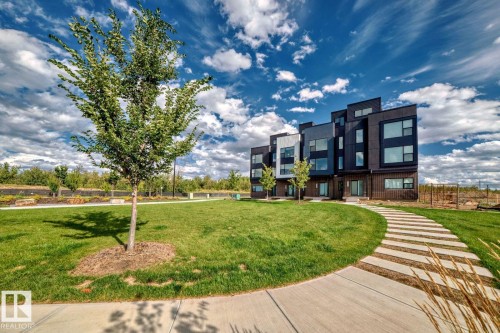 Contemporary multi-level townhome featuring a striking dark facade with contrasting light-colored panels and varied window placements - #66 5 Rondeau Dr, St. Albert, AB - Outdoor