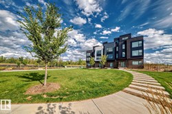 Contemporary multi-level townhome featuring a striking dark facade with contrasting light-colored panels and varied window placements - 