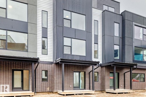Contemporary townhome exteriors featuring multi-textured facades with vertical siding and brick detailing - #66 5 Rondeau Dr, St. Albert, AB - Outdoor With Exterior