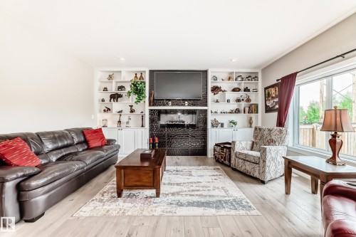 Built-in shelving flanking a textured fireplace - 3895 Robins Crescent, Edmonton, AB 