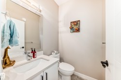 Bathroom featuring a modern vanity with integrated sink, chrome faucet, and white countertop - 