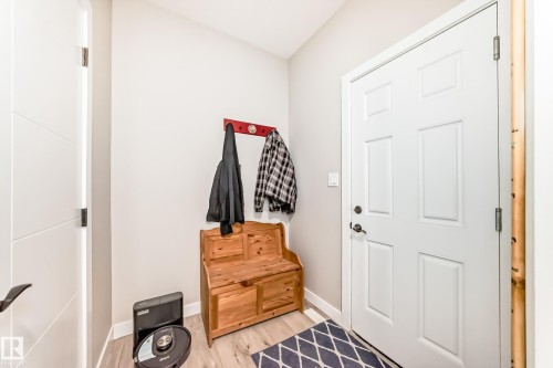 Entryway featuring wood-finish flooring, a white paneled door, and light gray walls - 3895 Robins Crescent, Edmonton, AB 