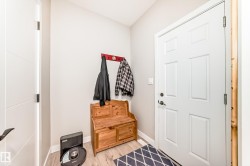 Entryway featuring wood-finish flooring, a white paneled door, and light gray walls - 