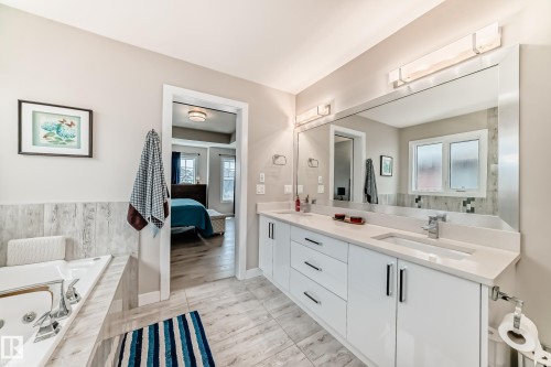Dual vanity with white cabinetry, integrated sinks, and polished chrome fixtures - 3895 Robins Crescent, Edmonton, AB 