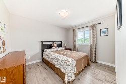 Bedroom featuring wood-finish flooring, a double window, and neutral wall tones - 