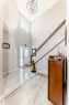 Entryway featuring a double-height ceiling, geometric chandelier, and transom window above the front door - 3895 Robins Crescent, Edmonton, AB 